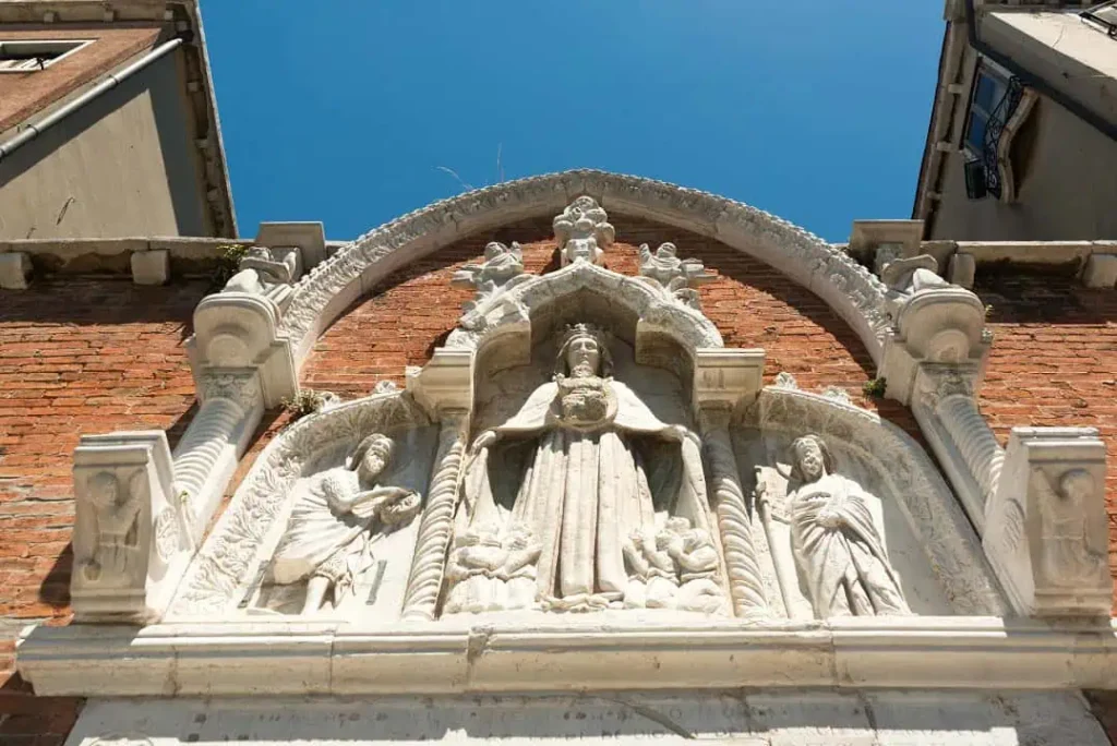 Antico rilievo in pietra d'Istria raffigurante figure sacre sulla facciata storica vicino al B&B Casa Baseggio a Cannaregio.